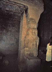 Fragmentary remains of Room 303 in Temple B300, showing small Bes statues, destruction of the chamber ceiling and walls due to collapse of blocks from the gebel; ©1982 Timothy Kendall, used with permission.