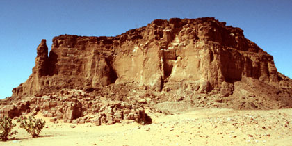 View west toward the gebel, with remains of a temple and the processional way in the foreground; ©1982 Timothy Kendall, used with permission.